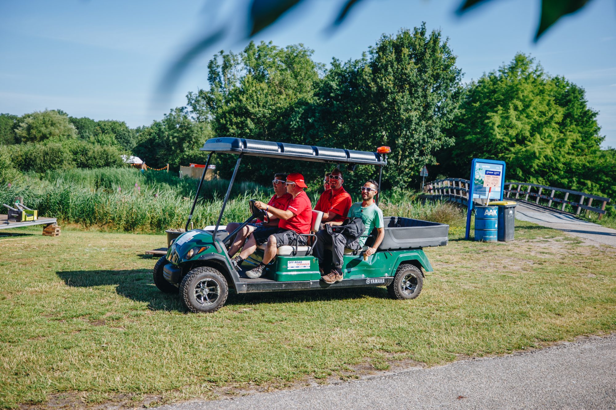 four construction people driving in a golf cart over festival grounds